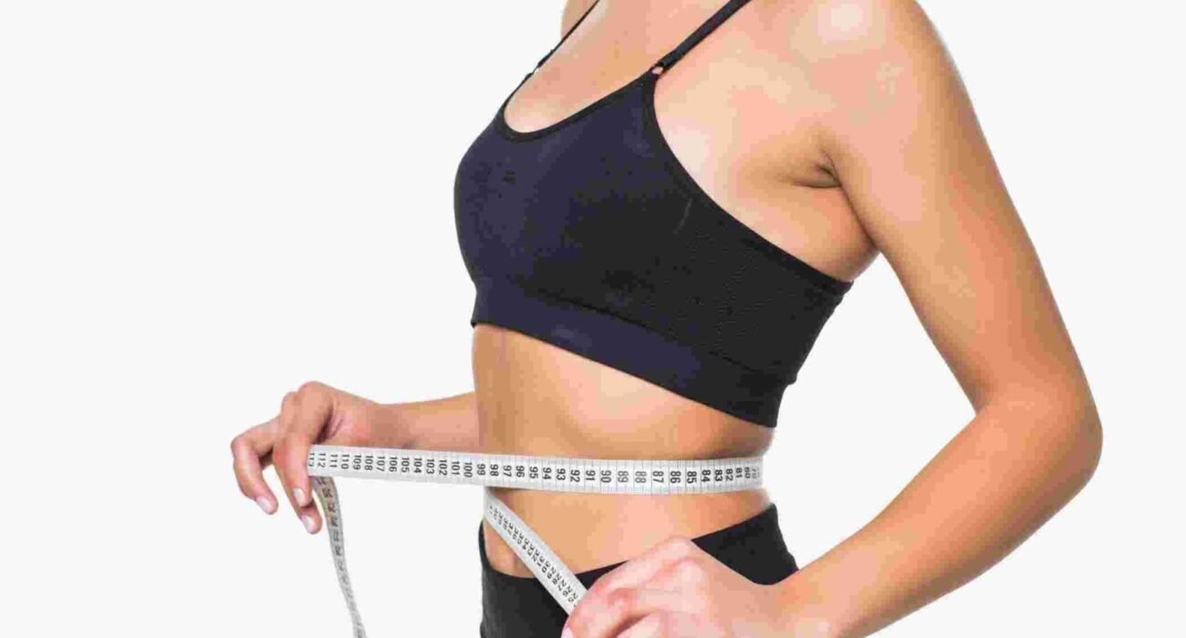 young-fitness-woman-measure-with-tape-her-belly-isolated-white-wall (1)